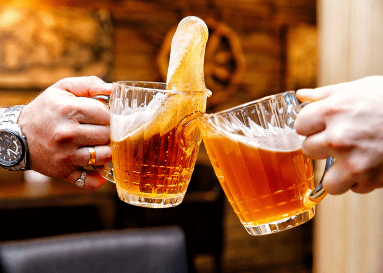 two hands holding full bear glasses
